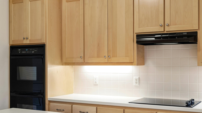 Wooden kitchen cabinets with accessories on top