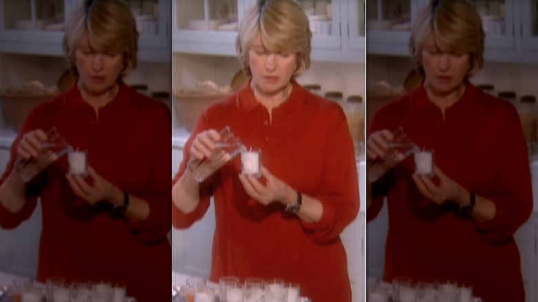 Martha Stewart pouring water into an unlit votive candle jar to prevent wax from sticking.
