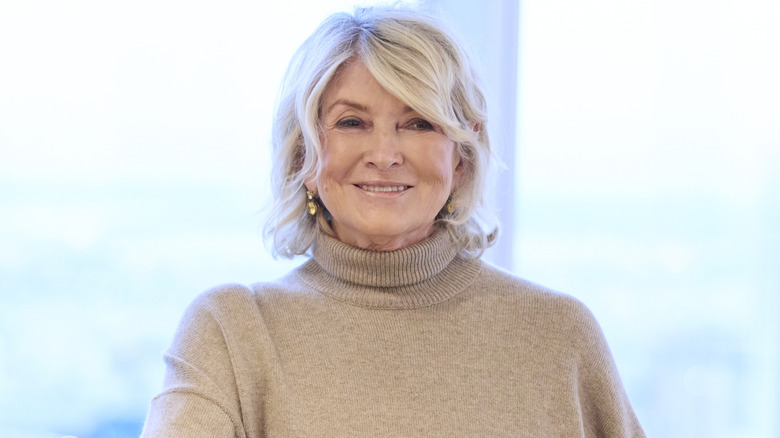 Martha Stewart wears a beige sweater and smiles at an event