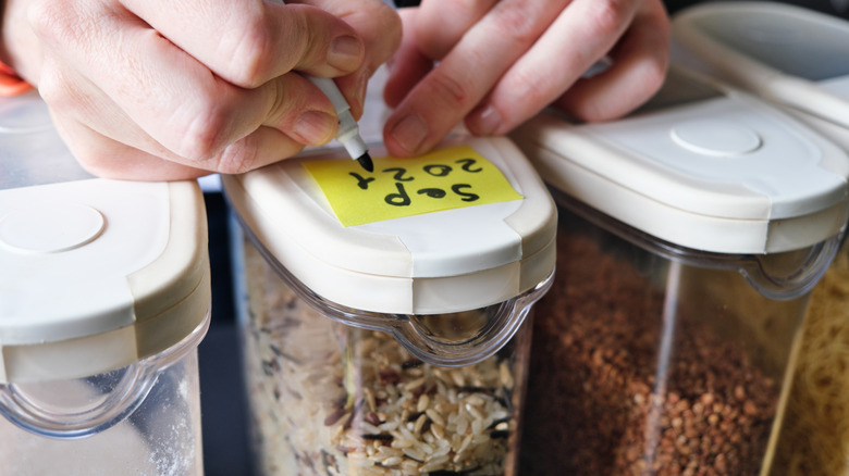 Woman writing dates on her pantry items to help with food rotation