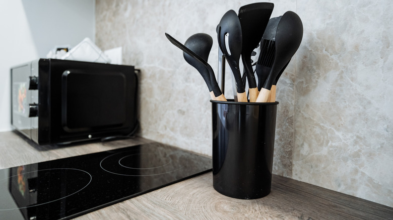 Vertical container holding cooking utensils next to a stove