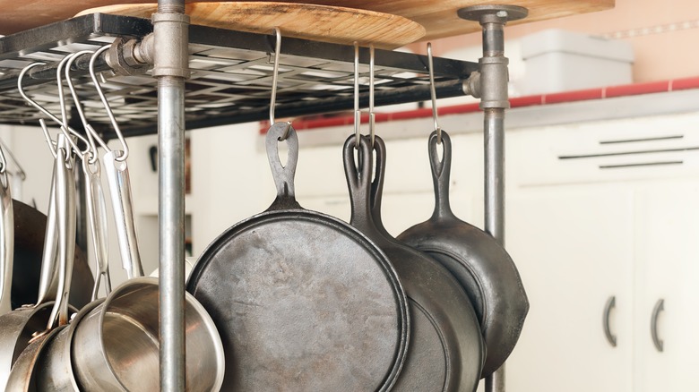 A ceiling-mounted rack with hanging pots and pans.