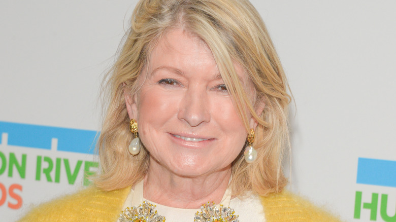Close-up of Martha Stewart with pear earrings and bright yellow sweater.