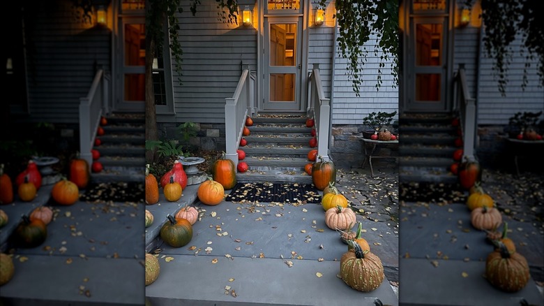 Pumpkins lining the steps and walkway of a home