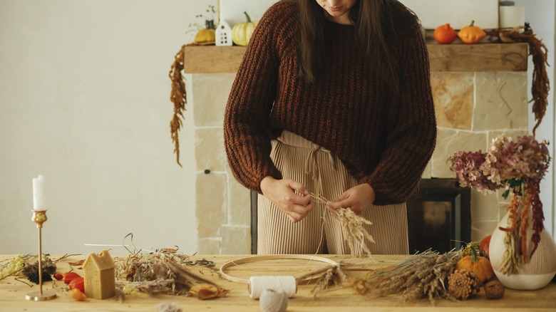 woman makes autumn wreath