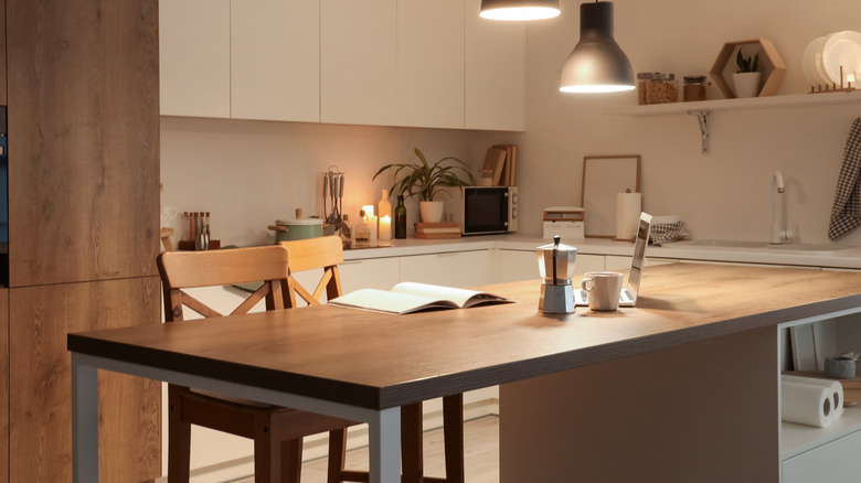 A kitchen with utensils, knives, cutting boards, and appliances stored out and within easy reach on the countertops