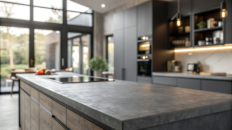 A close up view of a marble kitchen countertop with a blurry background of a modern kitchen.