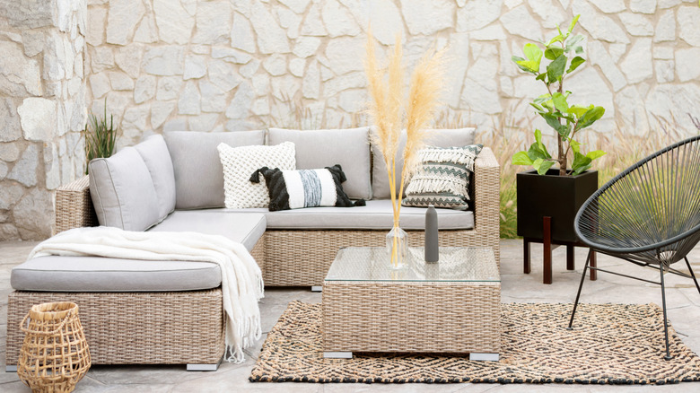 A patio with a rattan sectional sofa.