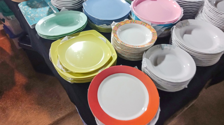 A table stacked with piles of melamine dishes.