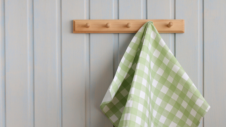 green and white tea towel hanging from a hook