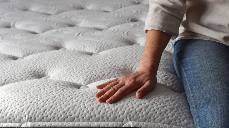 A person sitting on a memory foam mattress