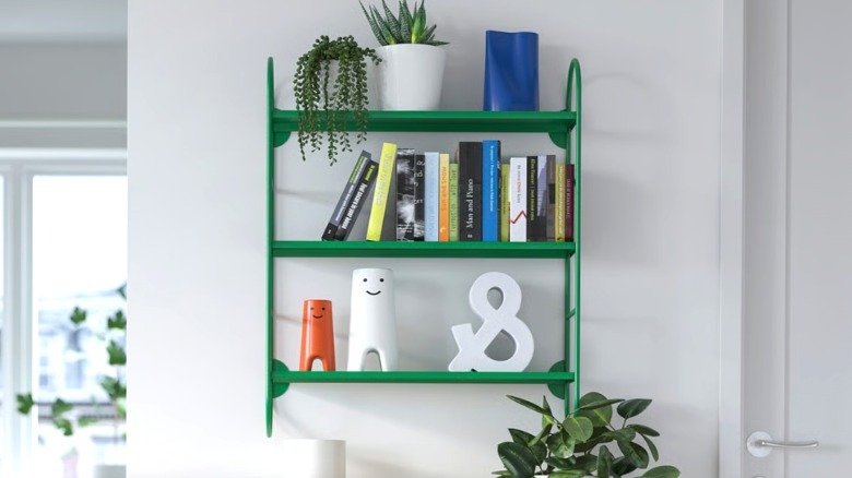 FÄRGSÄTTARE shelf with modern decor elements and books on entryway wall