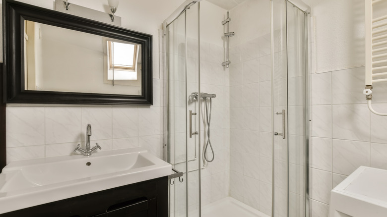 A black-framed mirror above a bathroom sink