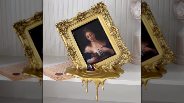 framed painting with a gold frame melting into a puddle over a shelf