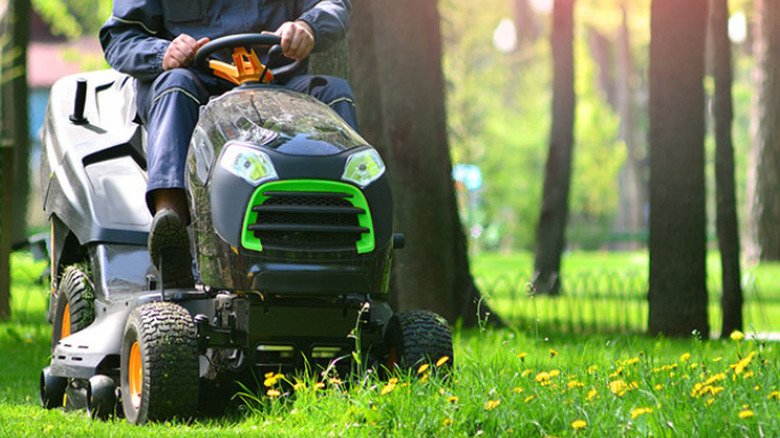 A man mowing a lawn on a ride-on lawn mower
