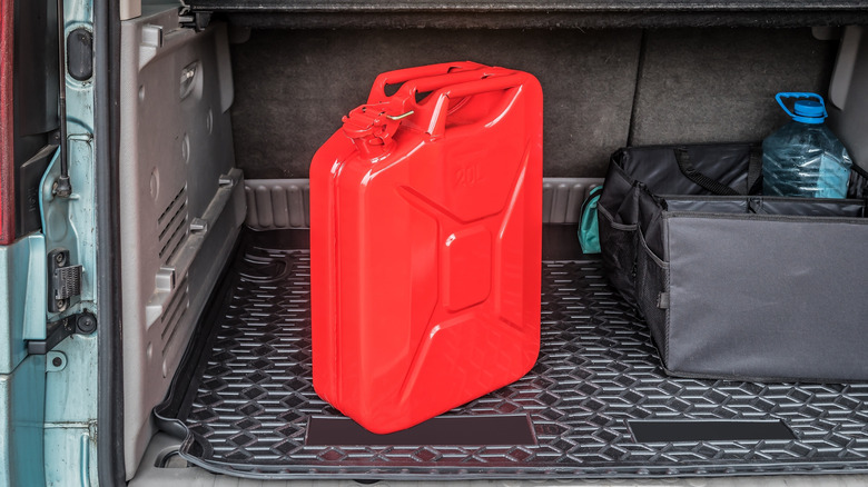 A metal gas can in the trunk of a car