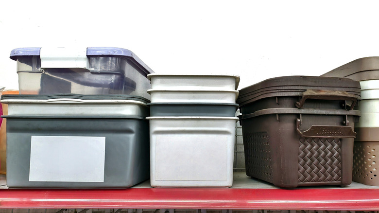 Plastic storage containers on a red shelf.