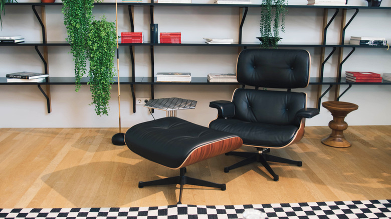 A black Eames lounge chair in a modern, trendy office