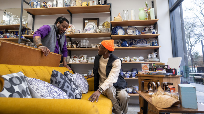 Two African American men shop for a vintage sofa.