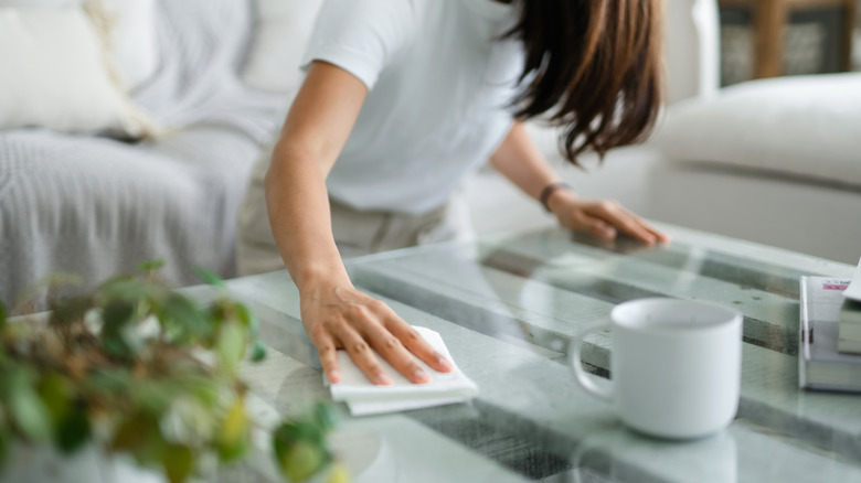 woman wiping coffee table