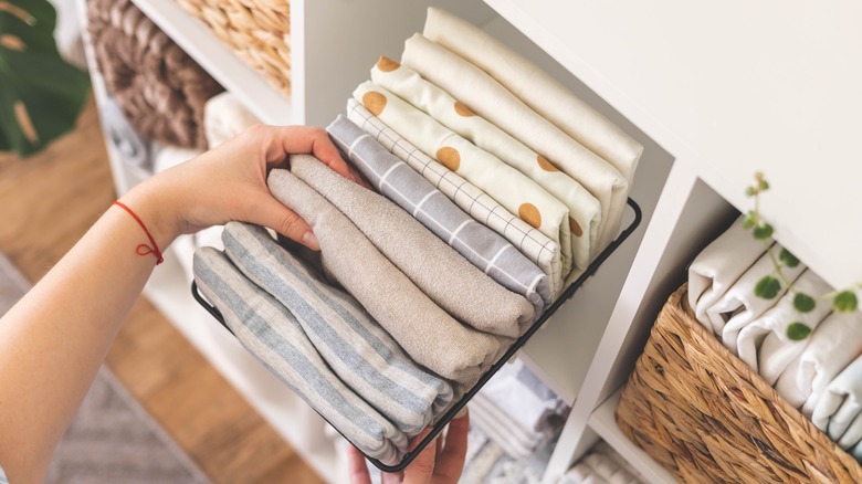 Person selecting organized bed linens