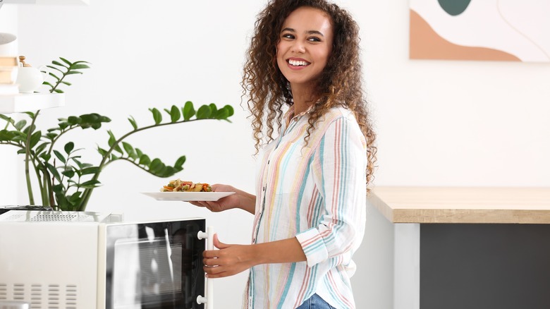 woman cooking in microwave