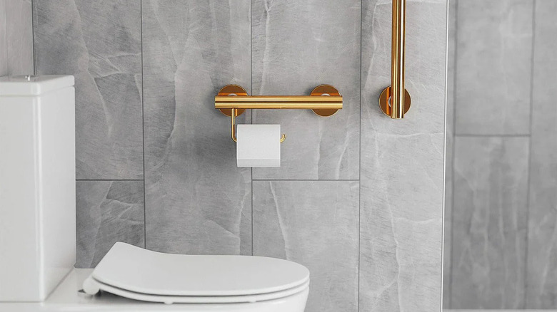 Gray bathroom with gold grab bars