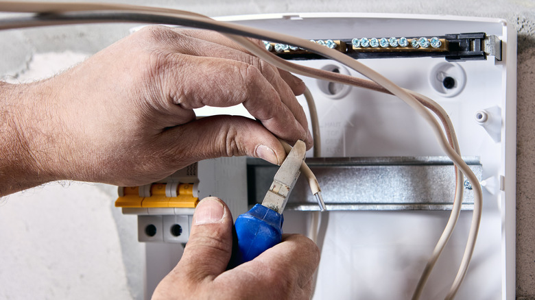 person working with aluminum wiring in electrical panel