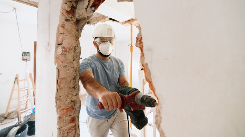 construction worker knocking down wall