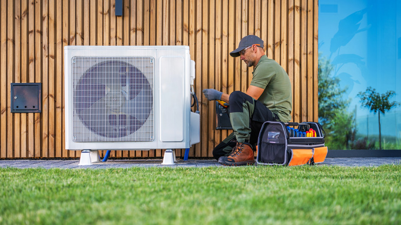 Technician installing an air conditioning system outside a home