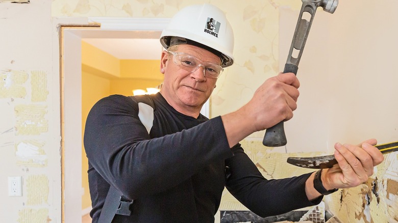 Mike Holmes doing demo on kitchen tile backsplash