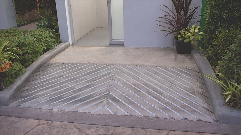 A sloping stone walkway leads up to an open doorway.
