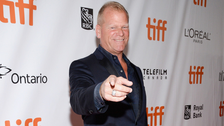 Mike Holmes points at the camera while posing at a festival