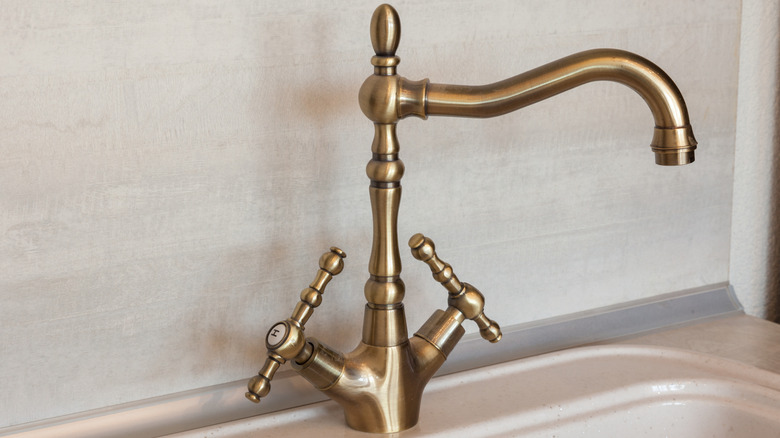 A brass faucet in a bathroom.