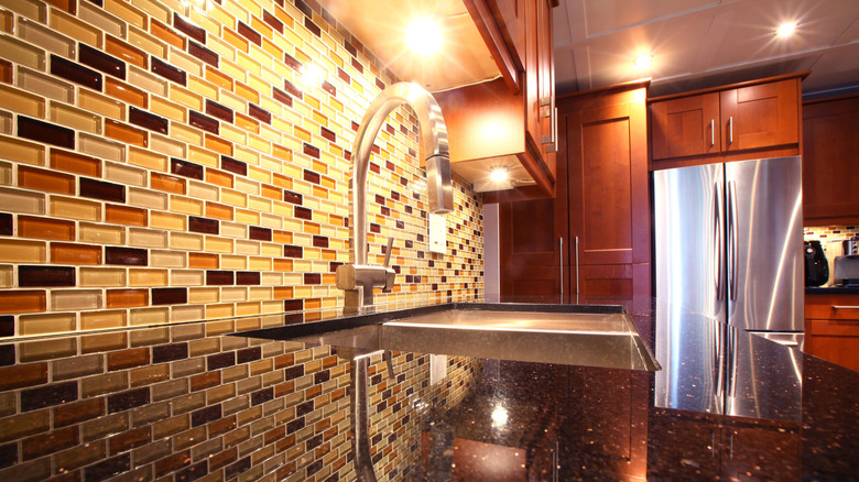 A modern kitchen with a mosaic tile backsplash.