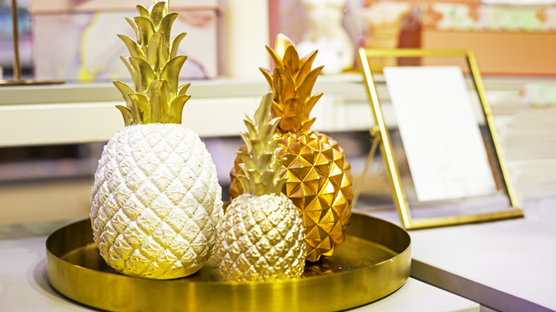 Brass pineapples in assorted sizes on a round brass tray.