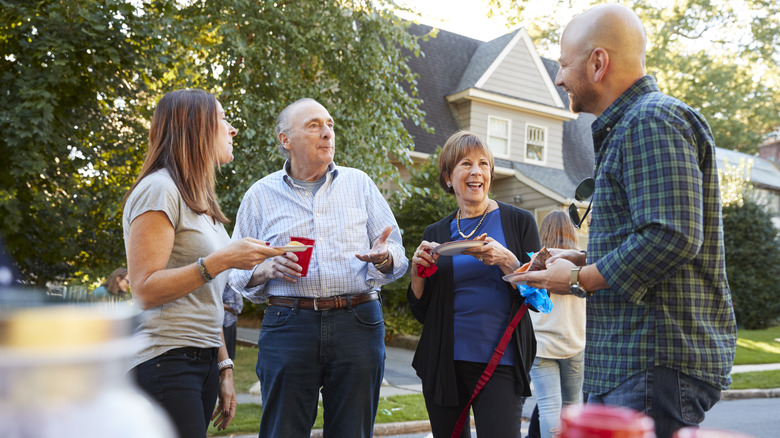 Young and old neighbors enjoying a block party in the street.