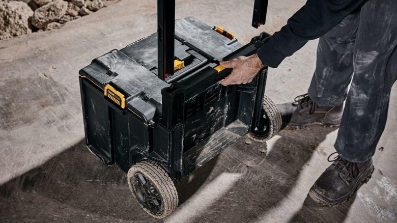 A person installing the handle on a DeWalt rolling tool box