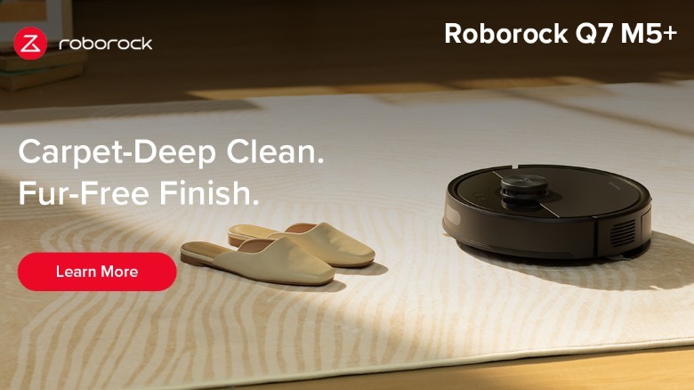 Roborock black Q7 M5+ robot vacuum on carpet with shoes