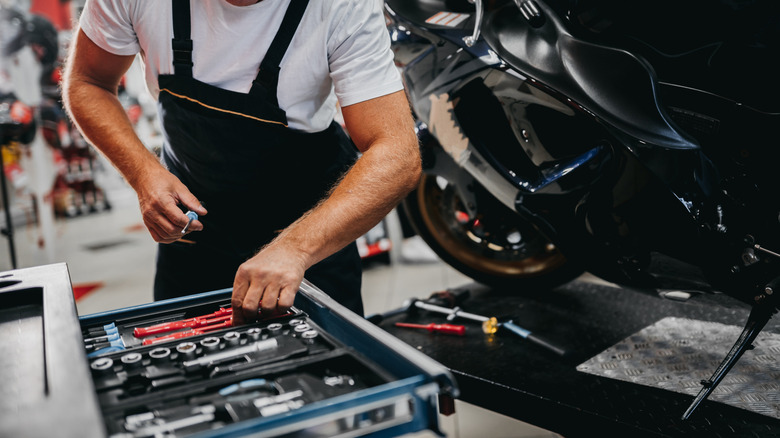 Man removing tools from a toolbox with a drawer