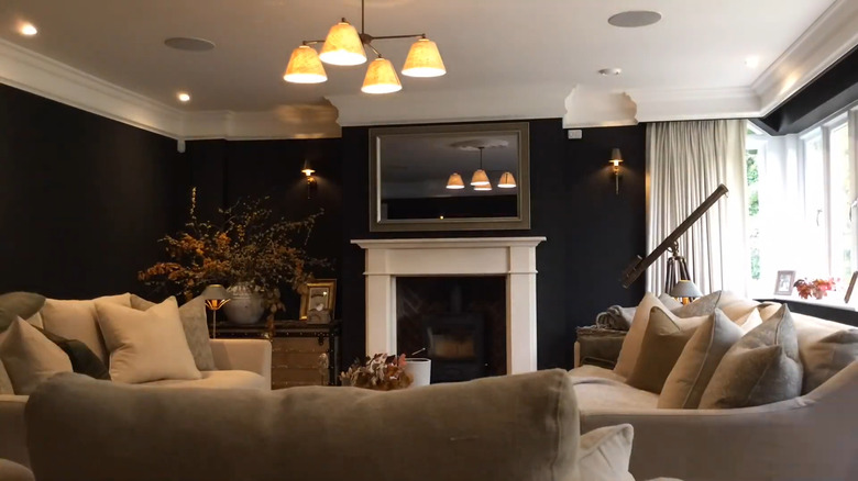 A framed mirror TV above a fireplace in the living room