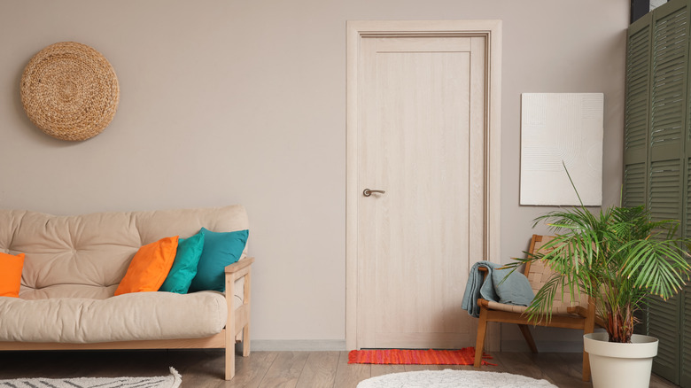 A living room with a door the same color as the wall