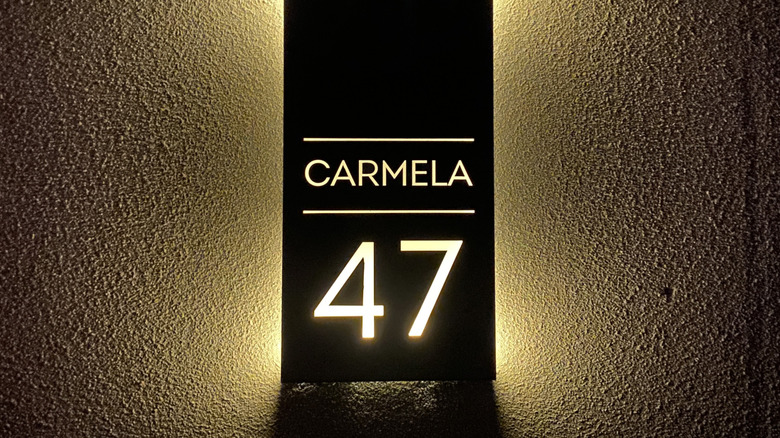 A sophisticated house number lit from behind at night