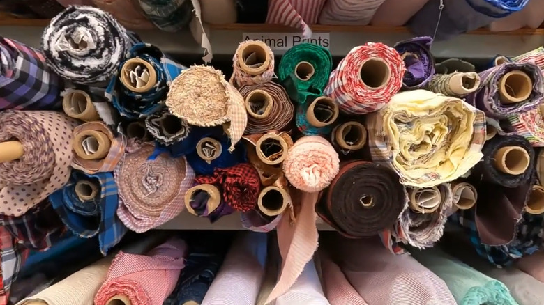 Interior of the brick-and-mortar location of Mood Fabrics in LA with cars parked along the black brick building.