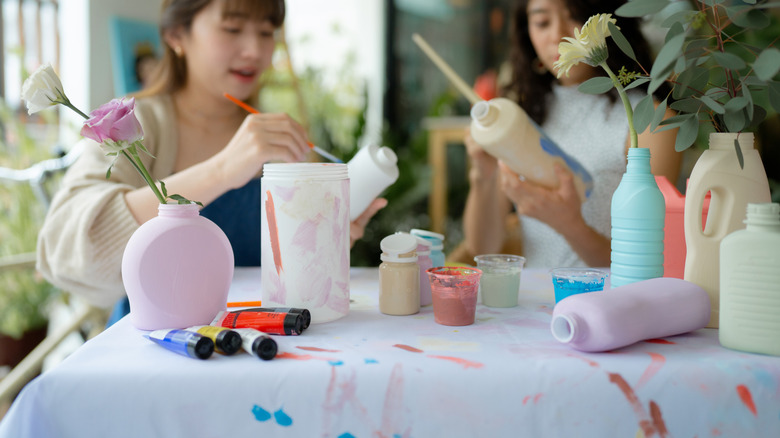 Woman painting plastic containers