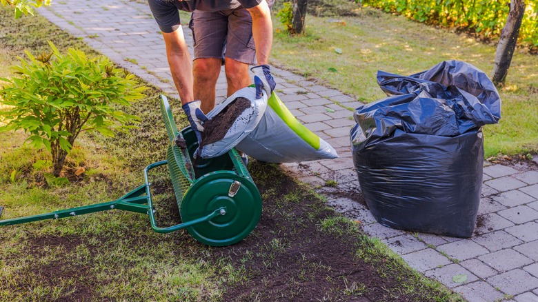 A person getting ready to topdress a lawn