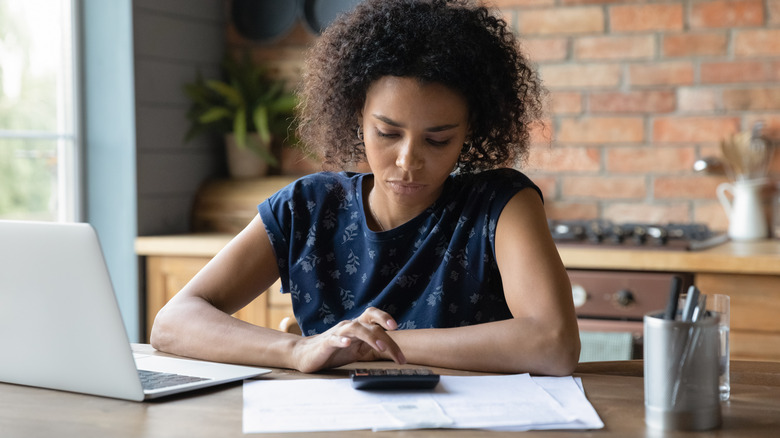 woman using calculator at home