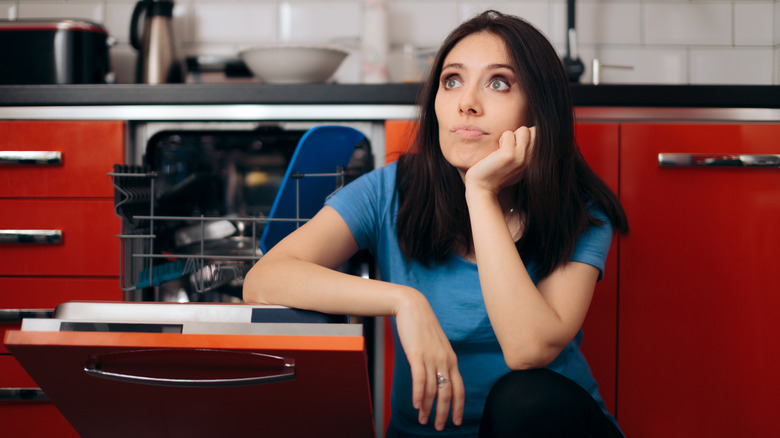 woman beside dishwasher and red cabinets