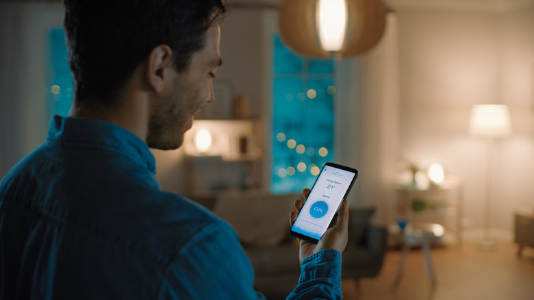 Man adjusts lighting with phone