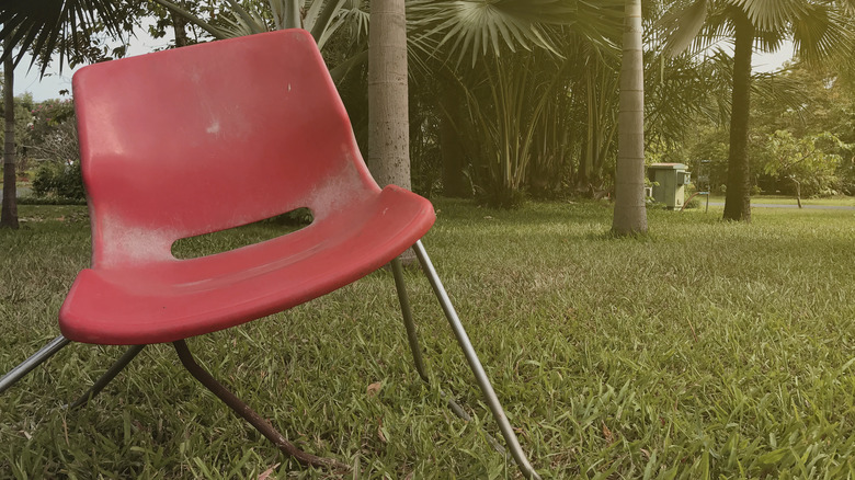broken red chair in grass